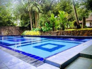 a swimming pool in a backyard with a stone wall at WG Villa Wathurugama in Kannimahara
