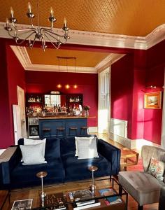 a living room with a blue couch and a bar at Birchwood Pitlochry in Pitlochry