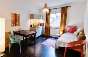 a bedroom with a bed and a desk and a kitchen at Schuhmacherei Rooms in Oestrich-Winkel