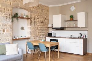 a kitchen and dining room with a table and chairs at La Calade Charming Apartment in Nîmes