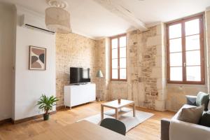 a living room with a couch and a table at La Calade Charming Apartment in Nîmes +6 photos