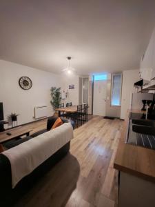 a living room with a couch and a dining room at Appartement Cosy in Louhans