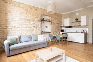 a living room with a couch and a table at La Calade Charming Apartment in Nîmes