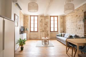 a living room with a couch and a table at La Calade Charming Apartment in Nîmes