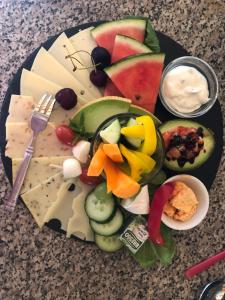 a plate of cheese and fruit on a table at Pension Waldfrieden in Thale +30 photos