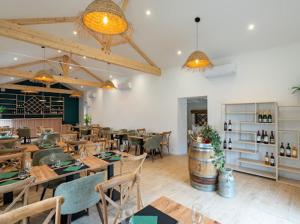 a restaurant with tables and chairs in a room at L auberge des marais proche Marennes Oléron in Saint-Just