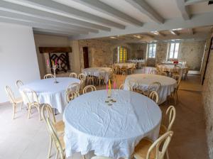 a room with white tables and chairs with candles on them at L auberge des marais proche Marennes Oléron in Saint-Just