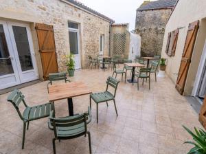 an outdoor patio with tables and chairs and tables and chairs at L auberge des marais proche Marennes Oléron in Saint-Just