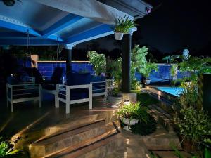 a patio at night with plants and a pool at Dr Doc's Family Lodge with Pool in Spur Tree