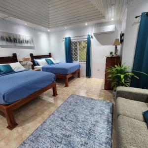a living room with two beds and a couch at Dr Doc's Family Lodge with Pool in Spur Tree +141 photos
