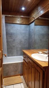 a bathroom with a tub and a sink and a bath tub at Ambiance Chalet in Tignes