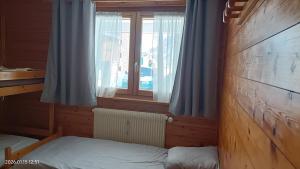 a small bedroom with a bed and a window at Ambiance Chalet in Tignes