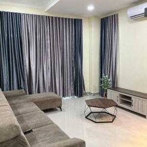 a living room with a couch and a tv at HD DOUBLE-STORY House in Banting