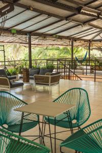 a patio with tables and chairs and a slide at The Cantamar Beach Hostel in Santa Marta