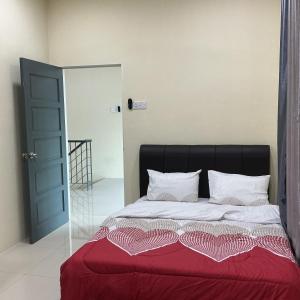 a bed with a black headboard and a red blanket at HD DOUBLE-STORY House in Banting