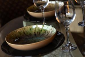 a bowl on a plate next to two wine glasses at Vencello Estelar Compostela in Santiago de Compostela +14 photos