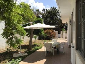 a patio with a table and an umbrella at Villa Antonietta in Torre Lapillo