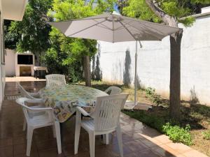 a table and chairs with an umbrella on a patio at Villa Antonietta in Torre Lapillo +6 photos