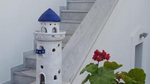 a white and blue lighthouse toy next to a staircase at Margarita Studios in Parikia
