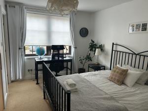 a bedroom with a bed and a desk and a window at The Pentland Apartment in Penicuik