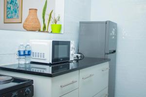 a kitchen with a counter top with a microwave at 1 bed apartment in Harare CBD in Harare +19 photos