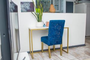 a blue chair sitting next to a small table at 1 bed apartment in Harare CBD in Harare
