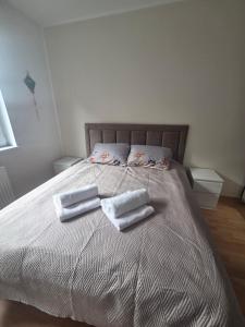 a bed with two towels and two pillows on it at Apartman Centar LUX in Jagodina