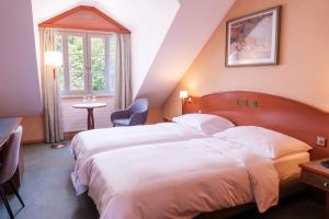 a hotel room with a large bed and a window at Hôtel du Port in Lausanne