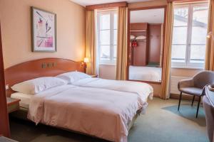 a hotel room with two beds and a window at Hôtel du Port in Lausanne