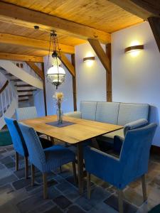 a dining room with a wooden table and blue chairs at Speicher in Soltau in Soltau