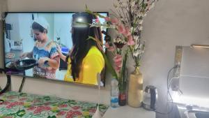 a tv on a wall with a picture of a girl at Big Room Ashdod in Ashdod