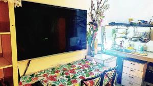 a kitchen with a tv and a table with a chair at Big Room Ashdod in Ashdod +2 photos