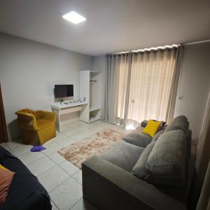 a living room with a couch and a television at Central House in Itajaí