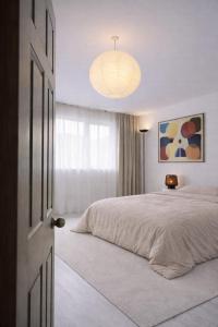 a bedroom with a large bed and a chandelier at blue house in Saint-Pierre