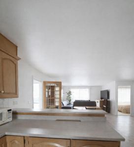 a kitchen with white walls and a living room at blue house in Saint-Pierre