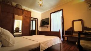 a bedroom with a bed and a dresser and a mirror at Soa Refuge in Antananarivo
