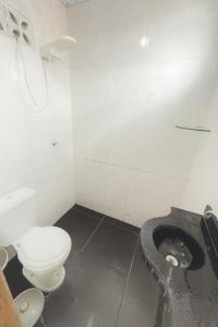 a white bathroom with a toilet and a sink at Casa disponível para o carnaval in Belém