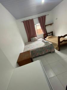 a small bedroom with two beds and a window at Casa disponível para o carnaval in Belém
