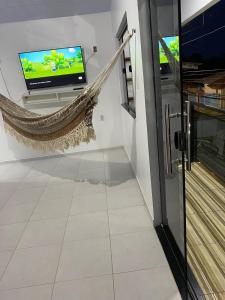 a living room with a television and a hammock at Casa disponível para o carnaval in Belém