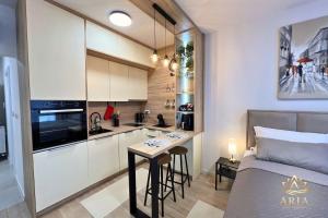 a small apartment kitchen with a table and a bed at ARIA Luxury Apartment, Tuzla in Tuzla