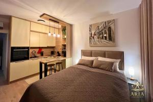 a bedroom with a large bed and a kitchen at ARIA Luxury Apartment, Tuzla in Tuzla +17 photos