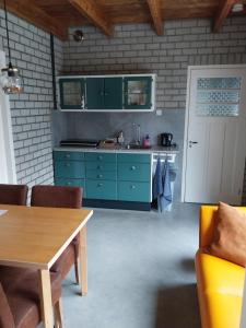 a kitchen with green cabinets and a wooden table at Gastenverblijf De Lopende Eend in Boxtel