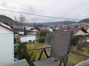 a chair on a balcony with a view of a town at Alea in Tuttlingen