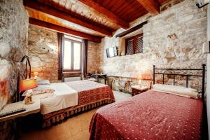 a bedroom with two beds and a stone wall at B&B Lo Gnomo in Pennapiedimonte