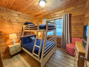 a bedroom with bunk beds in a log cabin at Chalet La Source Rouge in Saint-Raymond