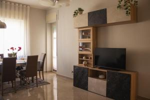 a living room with a television and a dining table at vivaldi casa vacanza in Caserta
