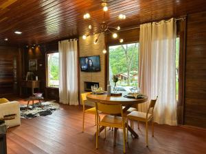a dining room with a table and chairs at Chale Allegra - Hidro Aquecida - Vista para o Lago in Venda Nova do Imigrante