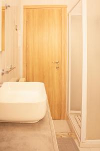 a bathroom with a white tub and a wooden door at vivaldi casa vacanza in Caserta +7 photos
