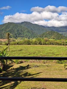a view of a field with mountains in the background at Cabaña Cherenga in Sarchí