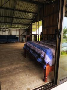 a bed in a room with a glass door at Cabaña Cherenga in Sarchí